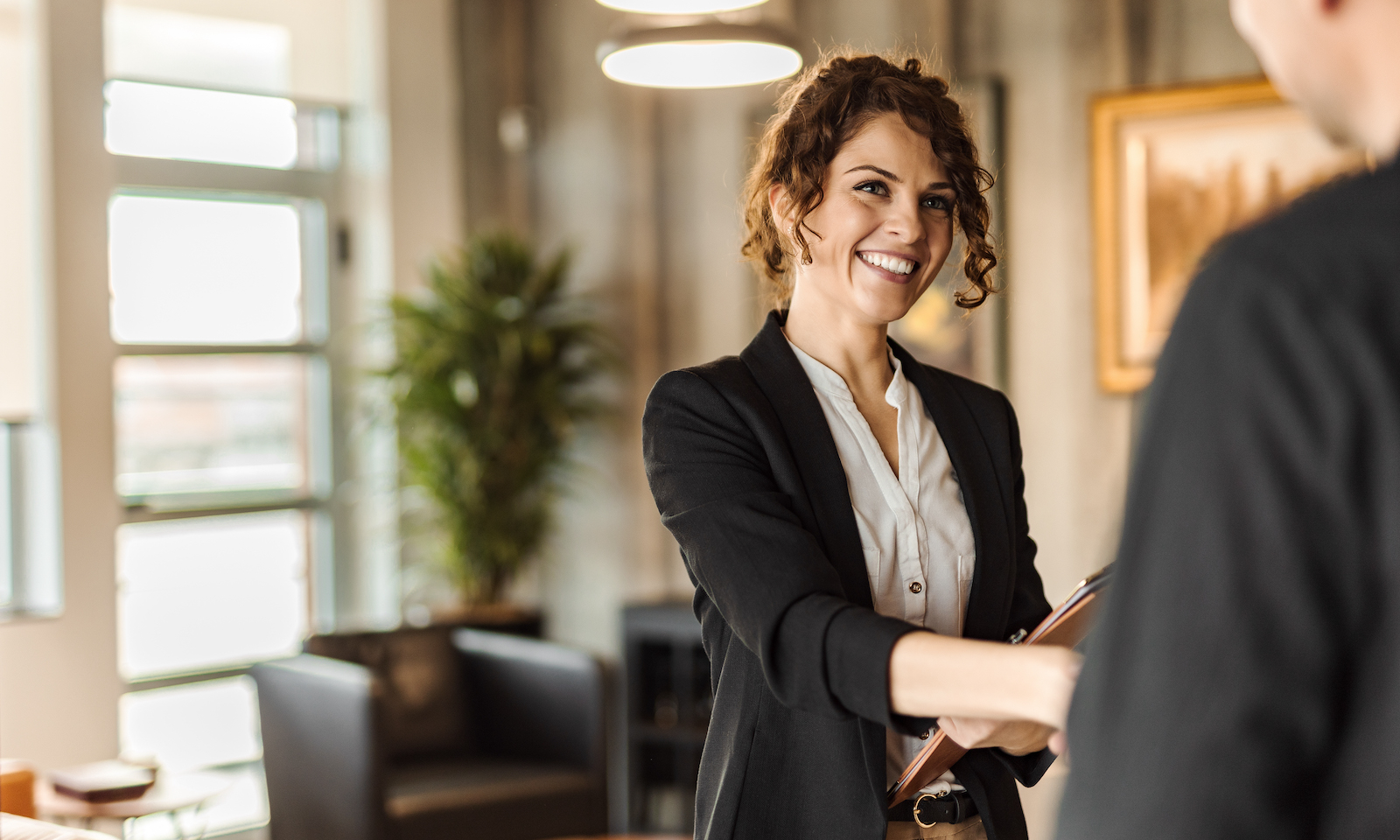 Working together, woman holding notebook.