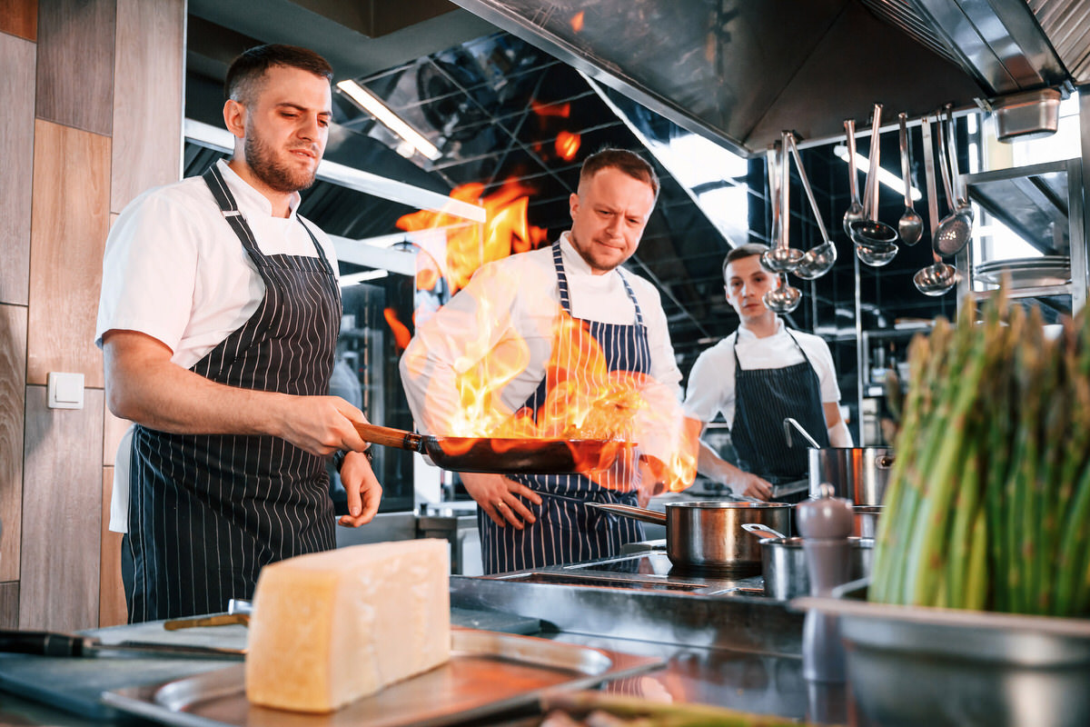 Frying the meat. Kitchen workers is together preparing the food