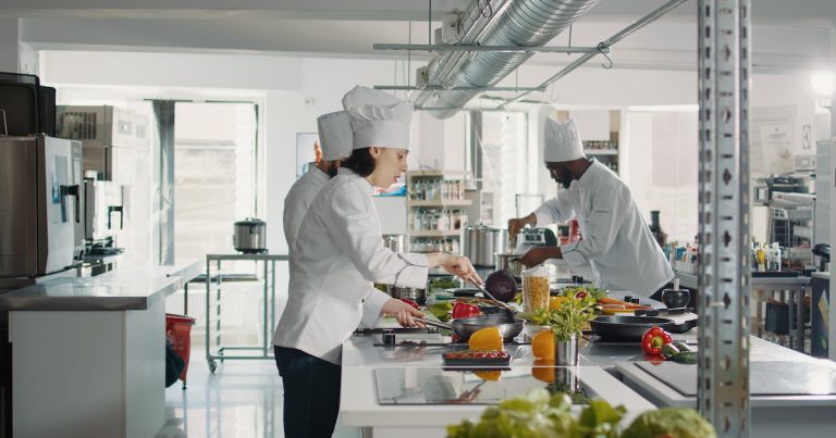 Female chef cooking gastronomy dish with vegetables on stove