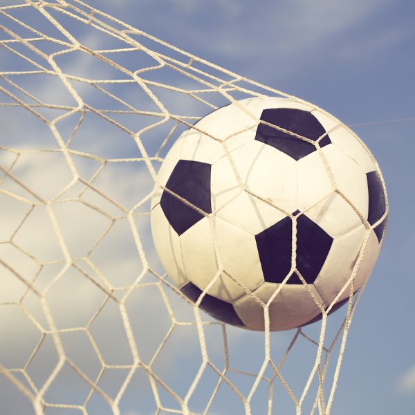 soccer ball in the net on blue sky background vintage color